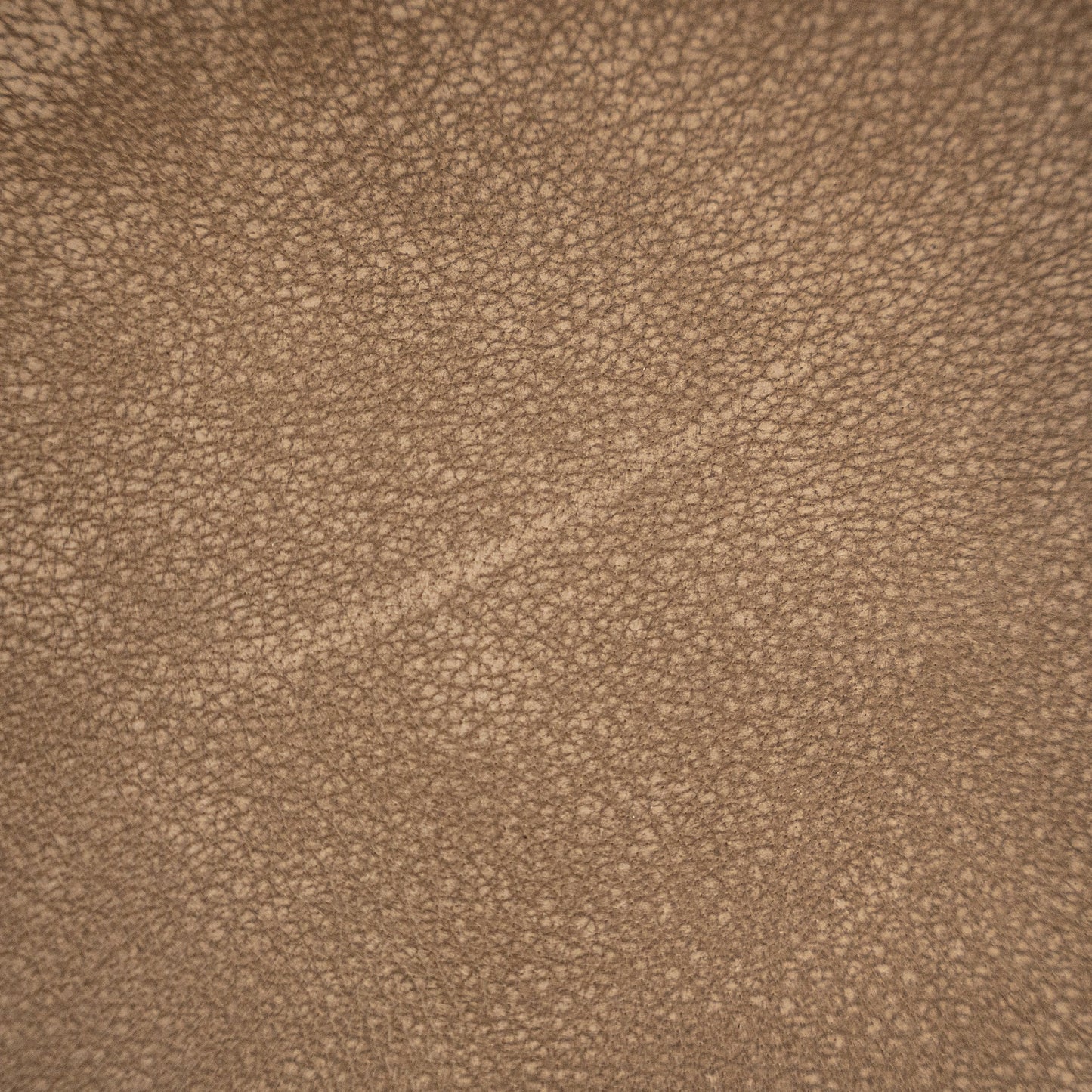 Close-up texture detail of enoki brown leather, showcasing natural grain and soft, luxurious finish