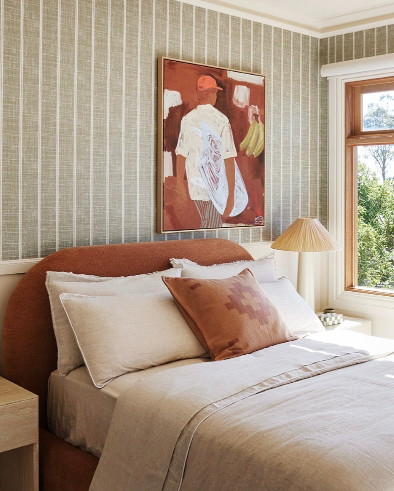 SOL Linen bedding and a terracotta cushion on an upholstered bed in House 18